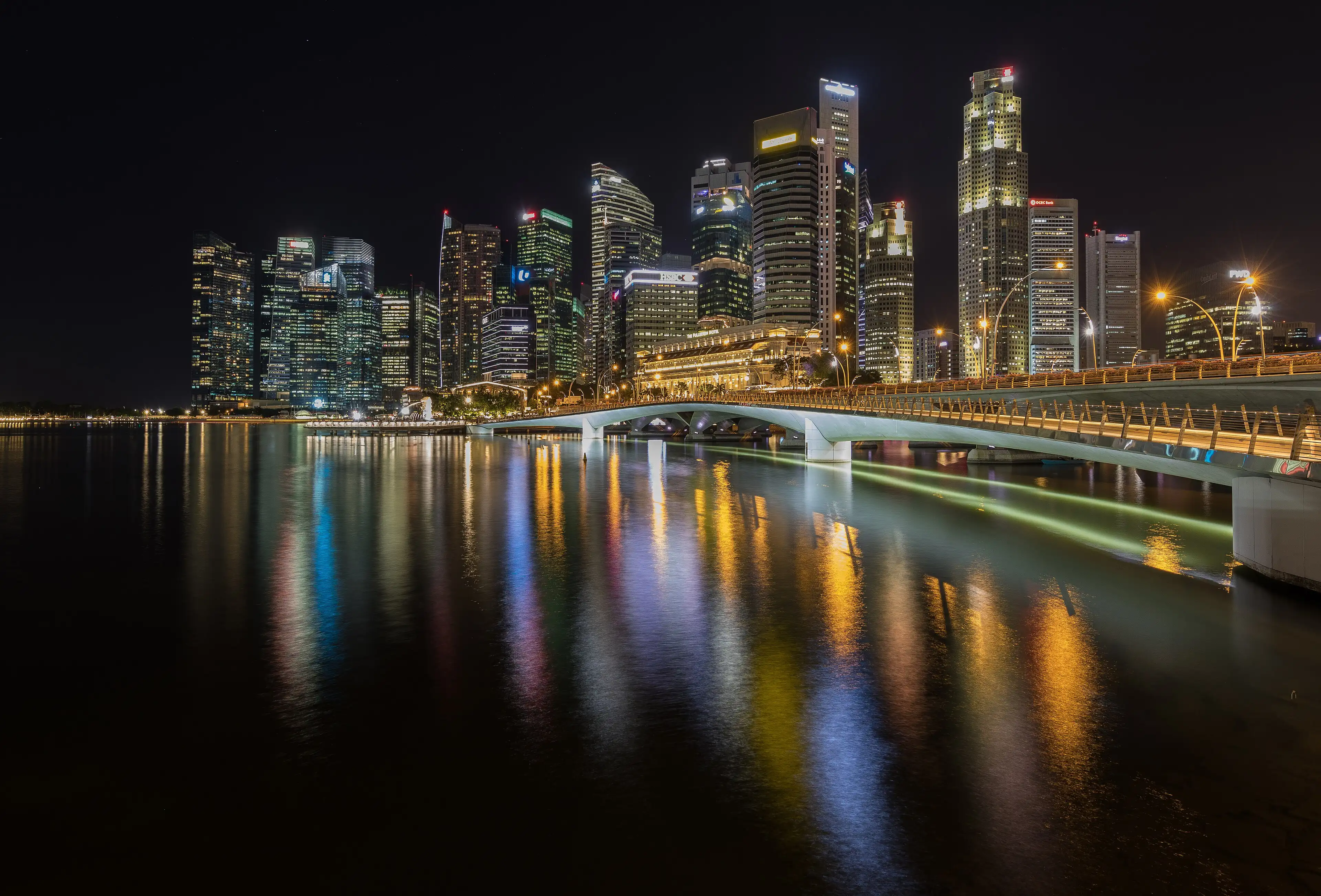 The Central Business District lit up at night, reflected in the water beside the Esplanade Bridge.